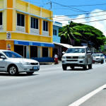 Urban Traffic Issues**

"A busy street scene in Majuro, Marshall Islands, showing a mix of cars and pedestrians. Focus on a family carefully crossing the street. Buildings are visible in the background, with some showing signs of wear. fully clothed, appropriate attire, safe for work, perfect anatomy, natural proportions, photojournalistic style, realistic lighting, high quality, professional"

**